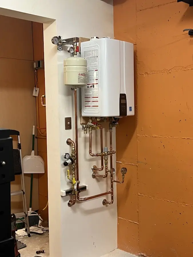 Plumbing technician inspecting water heater connections in Potosi